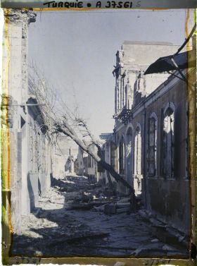 Image représentant Quartier arménien. Une rue bordée de bâtiments endommagés, un arbre tombé en travers (Rue Hadjimuçu)