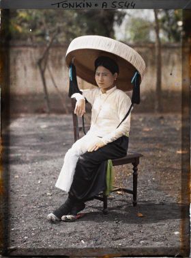 Image représentant Une jeune femme quarteronne portant le grand chapeau en feuilles de latanier muni d'une longue jugulaire ornée de pompons