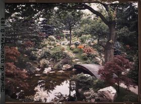 Image représentant Torii du " sanctuaire japonais " au sommet de la rive fleurie d'un cours d'eau