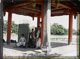 Image représentant Un groupe d'enfants sous le Thui-toa " Kiosque du bord de l'eau ", abritant une stèle de pierre nommée " Tablette du Temple de Van-xu'o'ng "