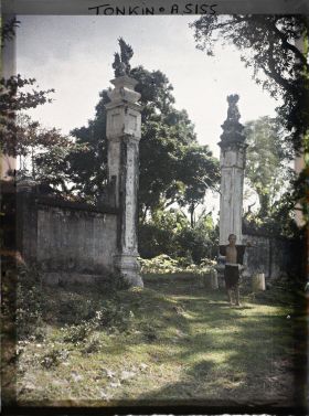 Image représentant Un villageois portant une palanche, devant l'entrée d'un temple