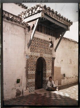 Image représentant Un adolescent assis sur le pas de la porte de la  null koubba de Sidi bou Médine