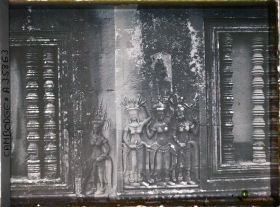 Image représentant Un relief d'apsaras sculpté entre deux fenêtres à balustres d'une galerie