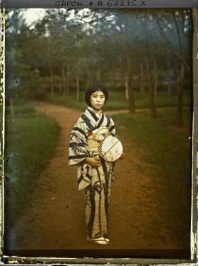 Image représentant jeune fille en kimono avec un éventail dans un jardin
