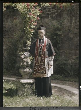 Image représentant Monseigneur Landais, archiprêtre de la cathédrale posant près d'une statue