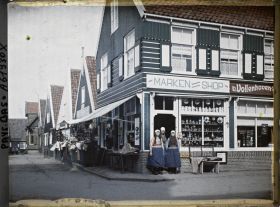 Image représentant Jeunes filles en costume de l'île à l'entrée d'un magasin de souvenirs
