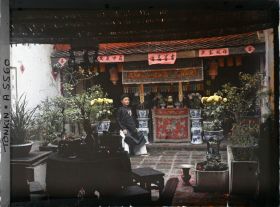 Image représentant Un notable près de l'autel des ancêtres dans la cour d'une maison aisée, au moment de la fête du Têt