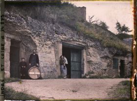 Image représentant Homme, Femme et enfants posant devant une cave troglodyte