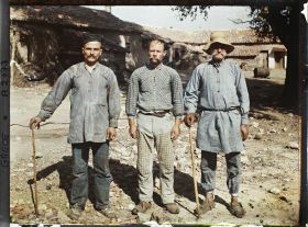 Image représentant Trois paysans (d'origine albanaise) dans une cour de ferme