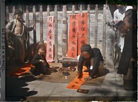 Image représentant Un artisan calligraphiant des " sentences parallèles " en vente à l'époque de la fête du Têt