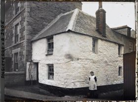 Image représentant Jeune fille devant une petite habitation