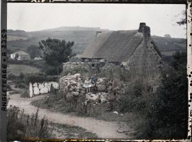 Image représentant Deux enfants assis près d'une maison