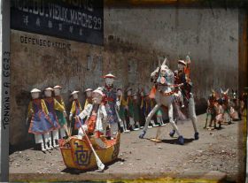 Image représentant Une exposition d'objets votifs en papier (barque, cavalier, personnages...), à l'angle de la " rue du Vieux Marché " et de la " rue des Médicaments "