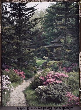 Image représentant Étroit chemin ombragé, orné de pierres et d'azalées, menant à la maison ouest du " village japonais "