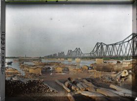 Image représentant Des sampans sur les quais du Fleuve Rouge, près du pont Doumer, aux dernières lueurs du jour