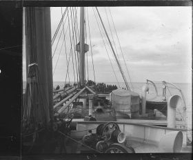 Image représentant Passagers sur pont supérieur vers l'avant du navire, au loin la côte américaine