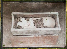 Image représentant Le cercueil en terre cuite, sans couvercle, où sont rassemblés les ossements du défunt après l'exhumation, lors d'une pratique funéraire (changement de sépulture)