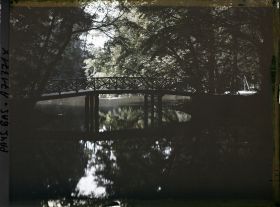 Image représentant Petit pont traversant une pièce d'eau ou un canal dans un parc