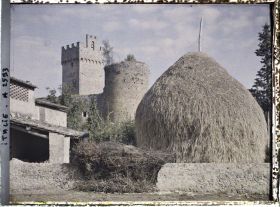 Image représentant Tours carrée et ronde devant un hangar et une meule de foin