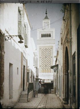 Image représentant La rue Sidi-ben-Arous dans la médina, dominée par le minaret de la Grande Mosquée