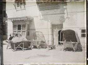 Image représentant Selles à chameaux couvertes, devant une maison