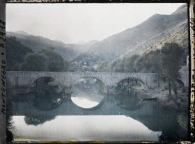 Image représentant Le pont, la rivière (avec reflets) et le village dans le lointain