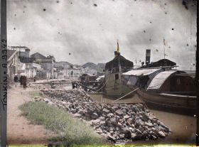 Image représentant Des sampans et une " chaloupe chinoise ", amarrés aux quais, devant des habitations