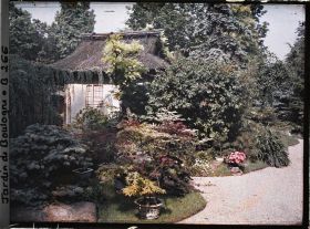 Image représentant Face est de la maison de thé cachée, en bord de chemin, par la végétation du " village japonais "