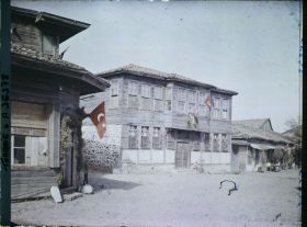 Image représentant Types de maisons à un étage en bois et en pierre, décorées de drapeaux turcs et de feuillages