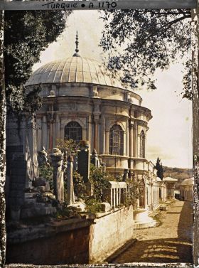 Image représentant Un mausolée et des tombes le long d'une rue pavée du cimetière de l'Eyüp Sultan Camii