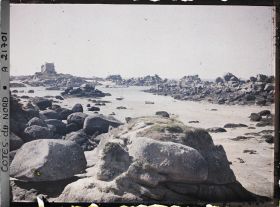 Image représentant Les rochers de la plage de Saint-Guirec avec à l'arrière-plan le château de Costaéres