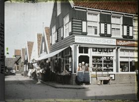 Image représentant jeunes filles en costume de l'île à l'entrée d'un magasin de souvenirs