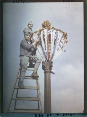 Image représentant Deux soldats décorant un lampadaire pour les fêtes de la Victoire des 13 et 14 juillet 1919