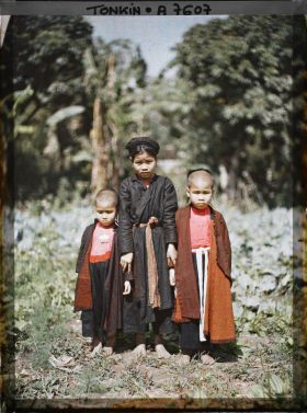 Image représentant Une jeune fille en turban tenant par la main deux enfants de moins de douze ans