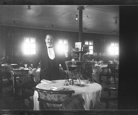 Image représentant Herr K. Nagel, Maître d'hôtel posant dans la salle du restaurant Ritz-Carlton des passagers des 1eres classes