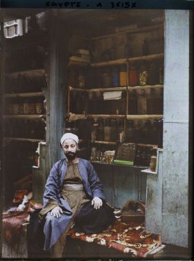 Image représentant Marchand de parfums assis dans sa boutique