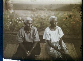 Image représentant Deux femmes âgées assises sur une natte de paille, assistant probablement à un cours sur le christianisme