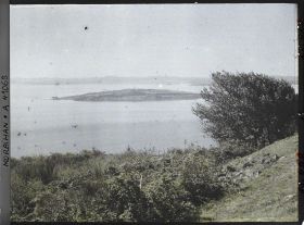 Image représentant L'îlot d'Er Lannic où l'on distingue plusieurs menhirs des cromlechs, vue prise de l'île de Gavrinis