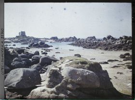 Image représentant Les rochers de la plage de Saint-Guirec avec à l'arrière-plan le château de Costaéres