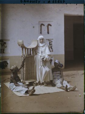Image représentant La mère Mélanie, supérieure de la mission catholique, près du trône de  null Guézo et entourée de deux femmes de  null Glélé