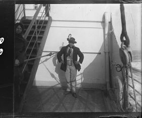 Image représentant Un passager des 3emes classes, vêtu d'un costume traditionnel d'Europe centrale ou d'Italie, probablement un émigrant, prend la pose sur l'entrepont
