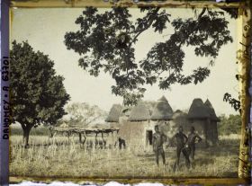 Image représentant Trois hommes somba devant un tata (case) et une plate-forme à sécher le mil