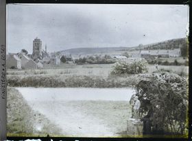 Image représentant Un reposoir sur le parcours de la Grande Troménie avec à l'arrière-plan le bourg de Locronan et la tour de l'église Saint-Ronan