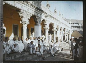 Image représentant Groupe d'hommes vêtus de blanc, assis sur les marches d'un temple hindou