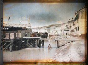 Image représentant Une " chaloupe chinoise ", amarrée aux quais, devant des habitations