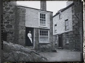Image représentant Femme se tenant sur le seuil de sa maison