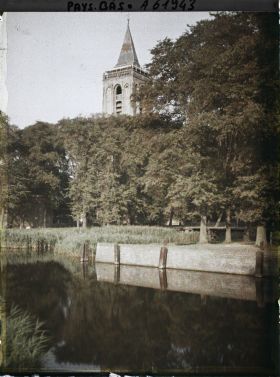 Image représentant L'étang situé près de l'église, à l'arrière plan le clocher