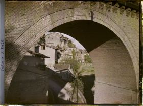 Image représentant Vue des maisons prise depuis une arche du pont de chemin de fer