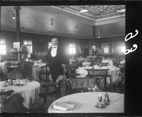 Image représentant Herr K. Nagel, Maître d'hôtel posant dans la salle du restaurant Ritz-Carlton des passagers des 1eres classes