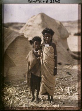 Image représentant Deux enfants  null bishari posent pour l'opérateur devant des habitations